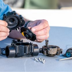 man adjusting sprinkler valve